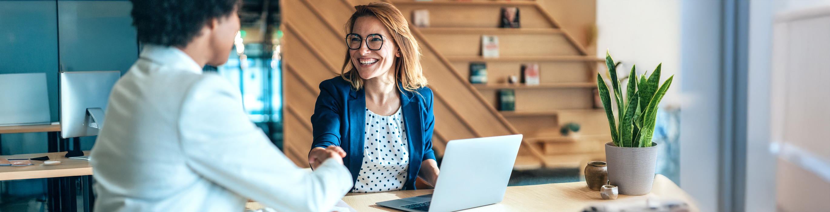 Personas dandose la mano en area de oficina