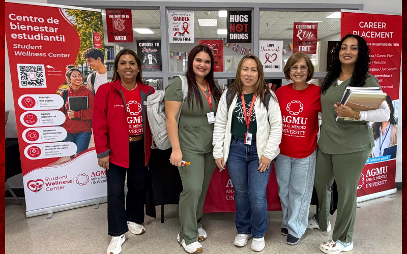 Personal de AGMU participa en Red Ribbon Week en Metro Orlando Campus, junto a materiales rojos de prevención y recursos de bienestar estudiantil.
