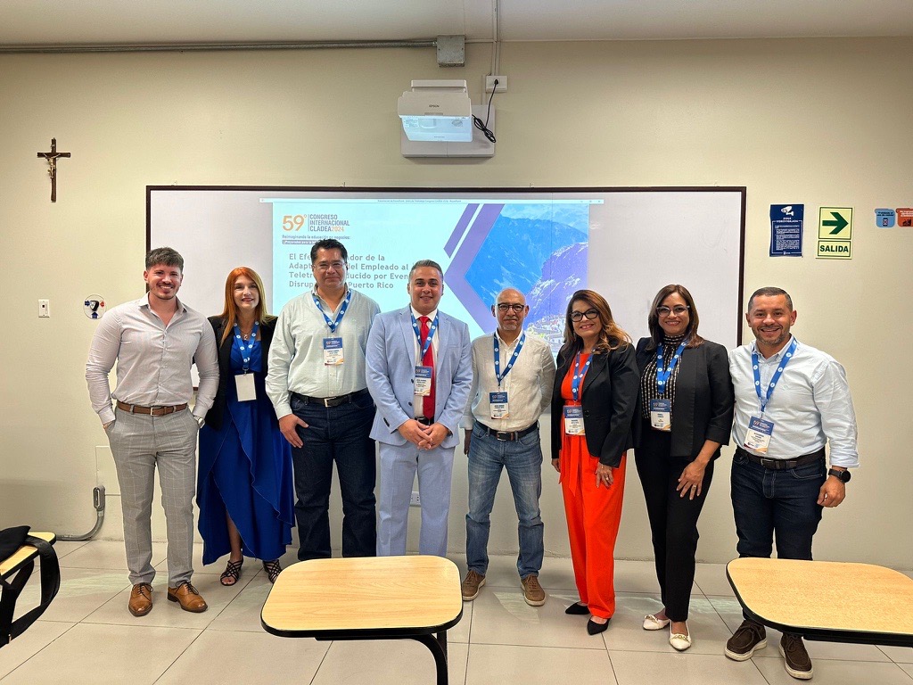 facultad cladea posando frente a presentación
